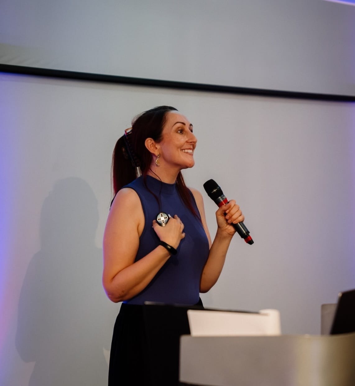 Katie mid-talk, holding a microphone